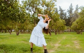 Девушка в белом платье закрыла глаза лимонами