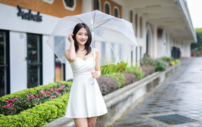 Asian woman in a white dress under an umbrella