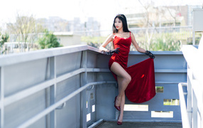 Азиатка в красном платье с короной на голове