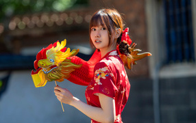 Азиатка в красном платье с бумажным драконом