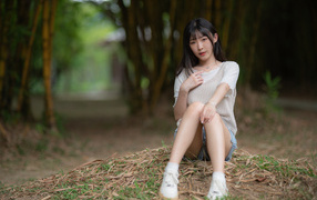 Asian woman sitting on the ground in the park