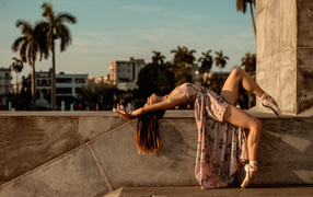 Девушка балерина в платье греется на солнце