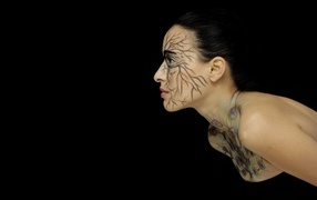 Красивая девушка с рисунком на теле на черном фоне