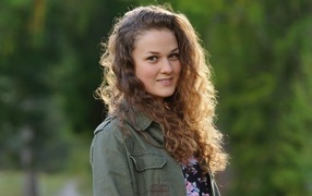 Красивая девушка с кудрявыми волосами в лучах солнца