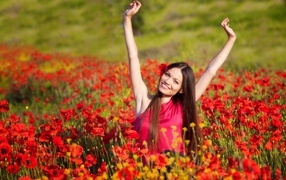 Красивая улыбающаяся девушка на поле с красными маками