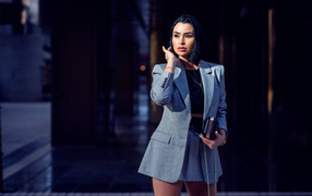 Деловая девушка в сером костюме с сумочкой