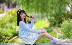 Милая азиатка в голубой кофте и в платье