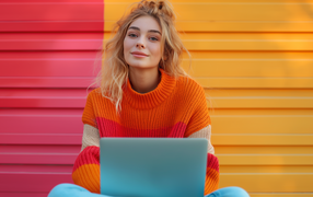 Милая девушка в свитере с ноутбуком