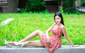 Длинноволосая азиатка в платье с белыми туфлями на ногах