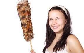 Улыбающаяся девушка убирается в комнате