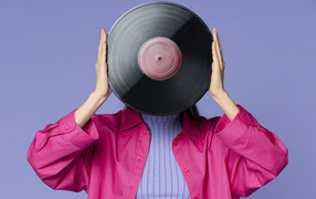 Девушка закрыла лицо пластинкой 