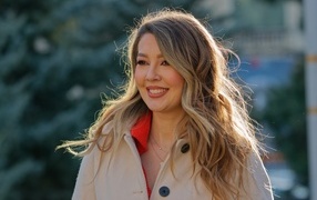 Женщина с милой улыбкой в пальто на улице