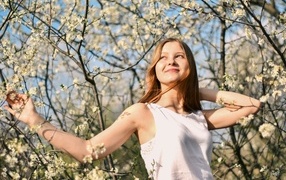 Молодая девушка у цветущего дерева весной