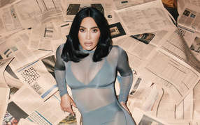 Модель Ким Кардашьян лежит на полу на газетах