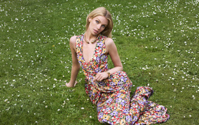 Модель Стелла Максвелл в платье сидит на траве