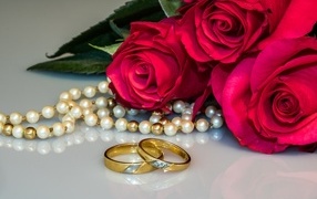 Два обручальных кольца с бусами и букетом роз 
