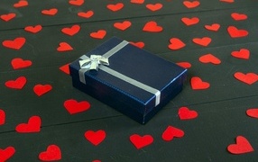 Черная коробка с красными сердечками на столе