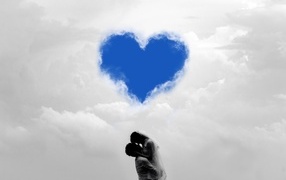 Пара на фоне сердца в небе в белых облаках