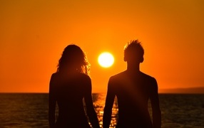 Влюбленная пара на фоне заката у моря