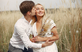 Поцелуй красивой пары на поле