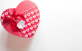 Большая подарочная коробка в форме сердца на белом фоне