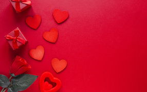 Бумажные сердечки с подарком и розой на красном фоне
