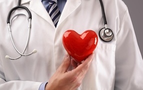 Красное сердце в руках доктора в белом халате