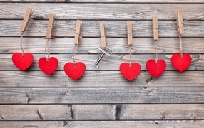 Красные сердечки и ключ с прищепками на веревке