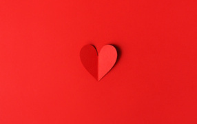 Маленькое бумажное сердце на красном фоне