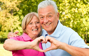 Улыбающаяся пара делает сердце руками