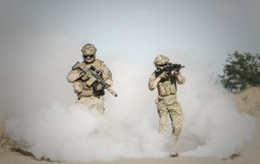 Мужчины солдаты с оружием в дыму