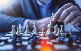 Мужчина играет в шахматы за столом