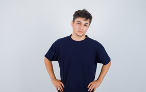 Молодой парень в синей футболке на сером фоне