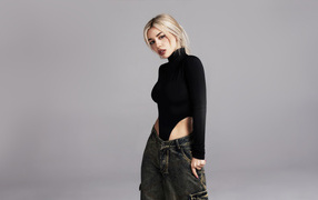 Милая блондинка певица  Эйва Макс на сером фоне