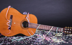 Гитара в конфетти у серой стены