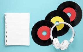 Пластинки на голубом фоне с блокнотом и наушниками