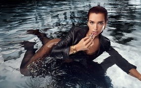 Певица Дуа Липа в черном наряде лежит в воде