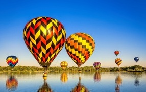 Большие воздушные шары над водой на фоне голубого неба