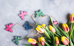 Букет коричневых тюльпанов с бабочками на сером фоне