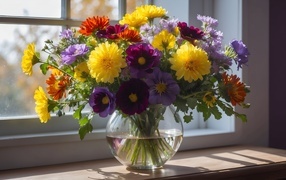 Bouquet of colorful flowers in a vase on the window