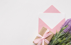 Конверт с цветами и подарком на белом фоне