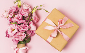 Большой букет эустомы с подарком на розовом фоне