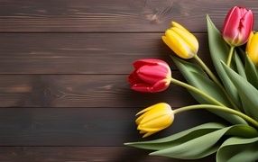 Желтые и розовые тюльпаны на деревянном столе