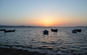 Лодки на морском побережье на закате