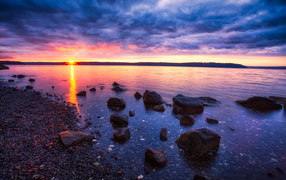Закат солнца в пасмурном небе у озера