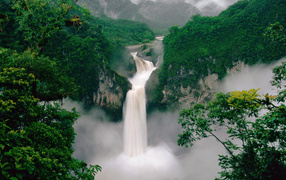 Большой водопад стекает с покрытых зеленью гор