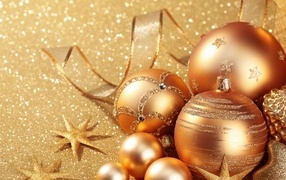 Золотые елочные шарики со звездами на блестящем фоне