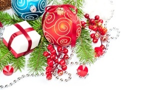 Разноцветные елочные игрушки с ветками на белом фоне