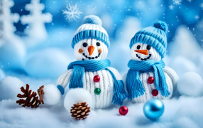 Два снеговика в шапках на снегу с шишками