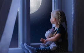 Маленькая девочка с игрушкой смотрит у окна на луну
